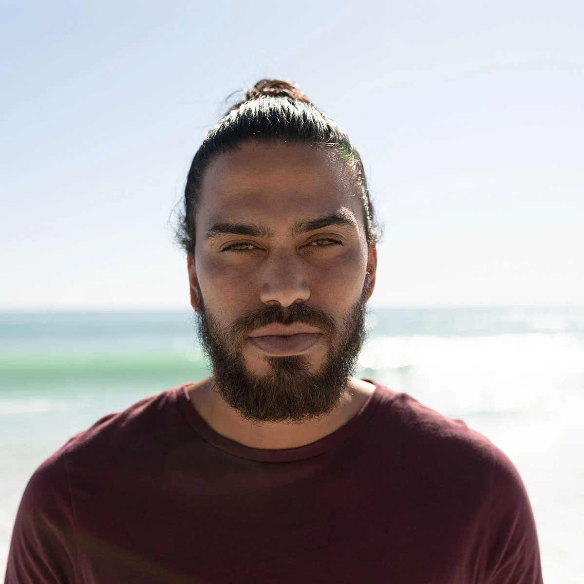 young mixed race man portrait on the beach K3GM4V6